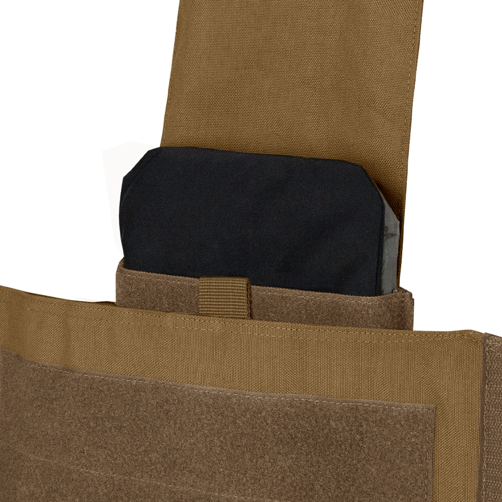 A close-up of a black ballistic plate partially inserted into the pocket of a tan Condor Modular Operator Plate Carrier Gen II.